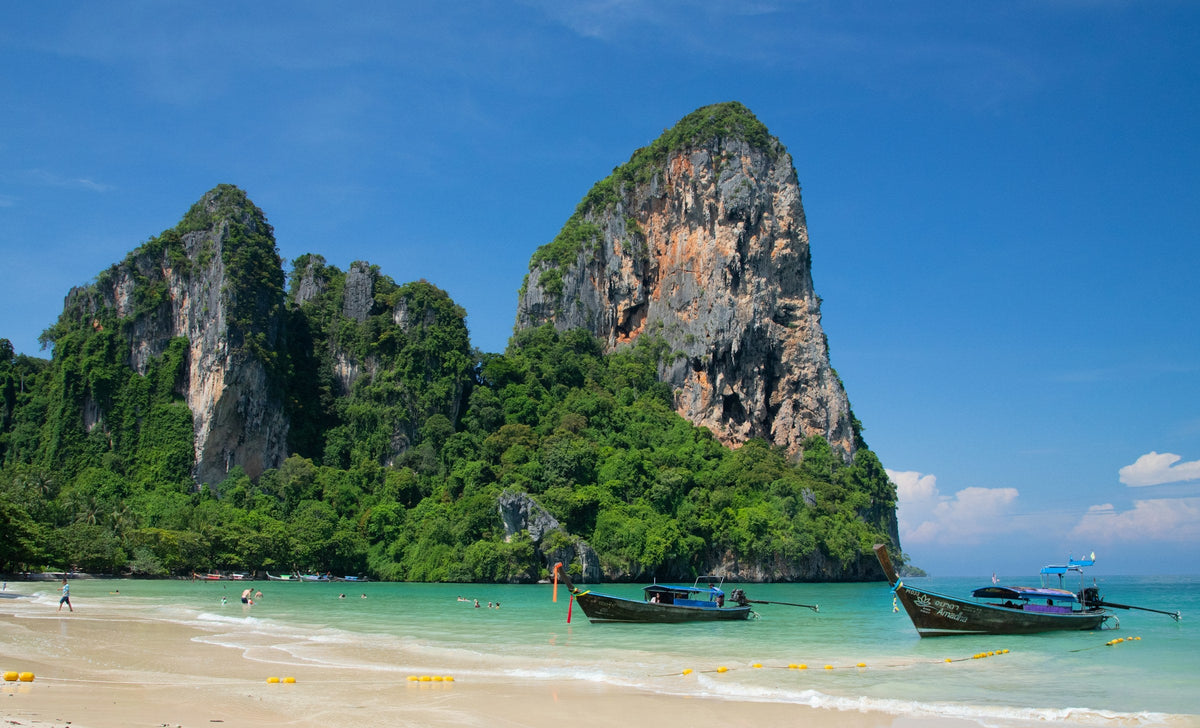 Longtail boats on Railay Beach below limestone cliffs, Krabi, Thailand