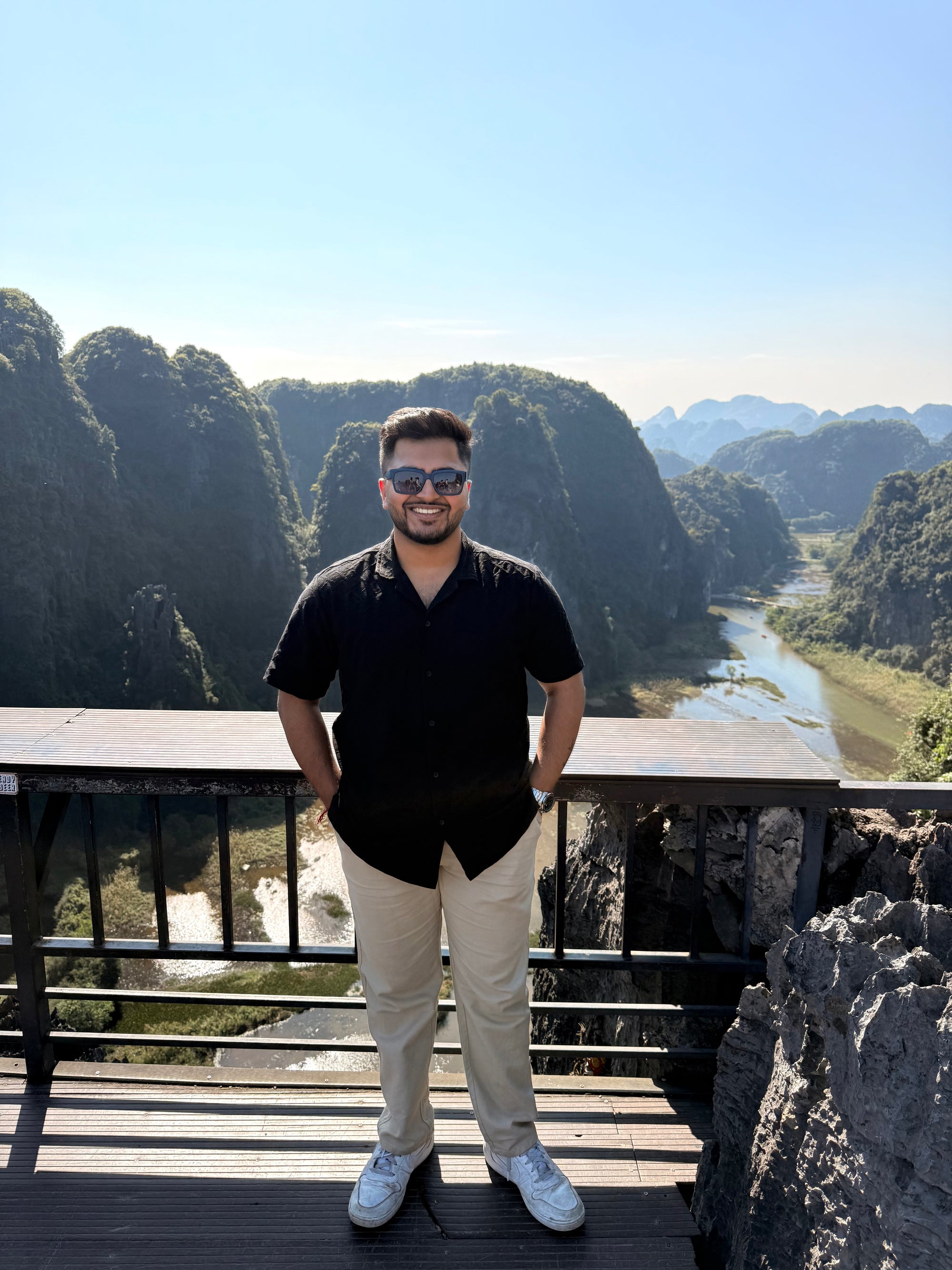 Manav, founder of Unpinned, standing at a viewpoint above limestone karsts