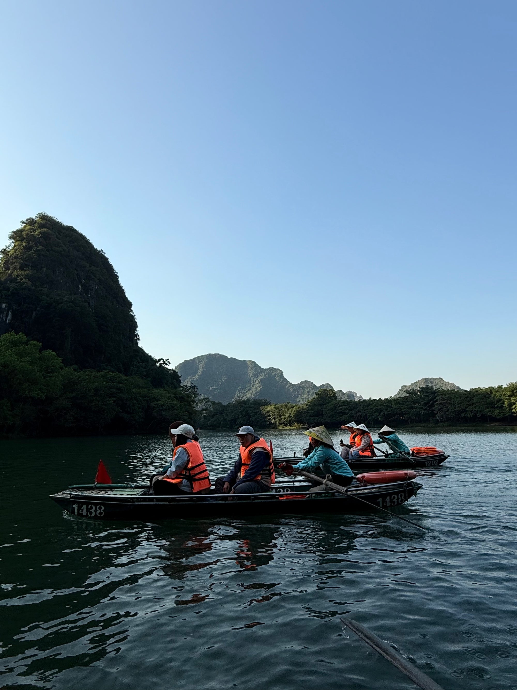 Travellers in rowing boats beneath limestone karsts in Ninh Binh, Vietnam