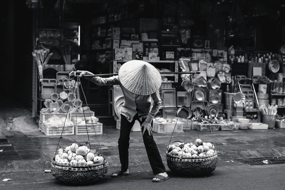 A fruit seller with baskets in Hanoi's Old Quarter, Vietnam